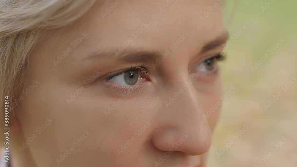 Close up. Green eyes of young caucasian blond woman in the park. High quality photo Close up. Green eyes of young caucasian blond woman in the park. High quality photo