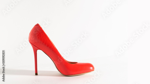Bright red shoes on the white background. Side view picture. Beautiful high heels shoes. Element for design. Space for text.