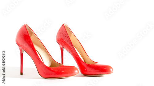 Bright red shoes on the white background. Side view picture. Beautiful high heels shoes. Element for design. Space for text.