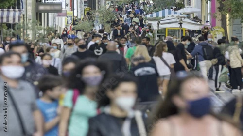 time lapse of a crowd goes up and down a busy shopping street wearing a protective mask for covid19