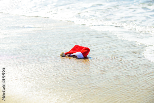 Santa Claus Hat on sea beach. Christmas vacation. Hot New Year.