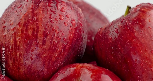 Still shot close up of red apple group pile with water slide down on skin surface, white background