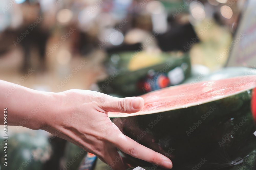 close up hand with watermelon in supermarket. Concept for grocery and fruit market.