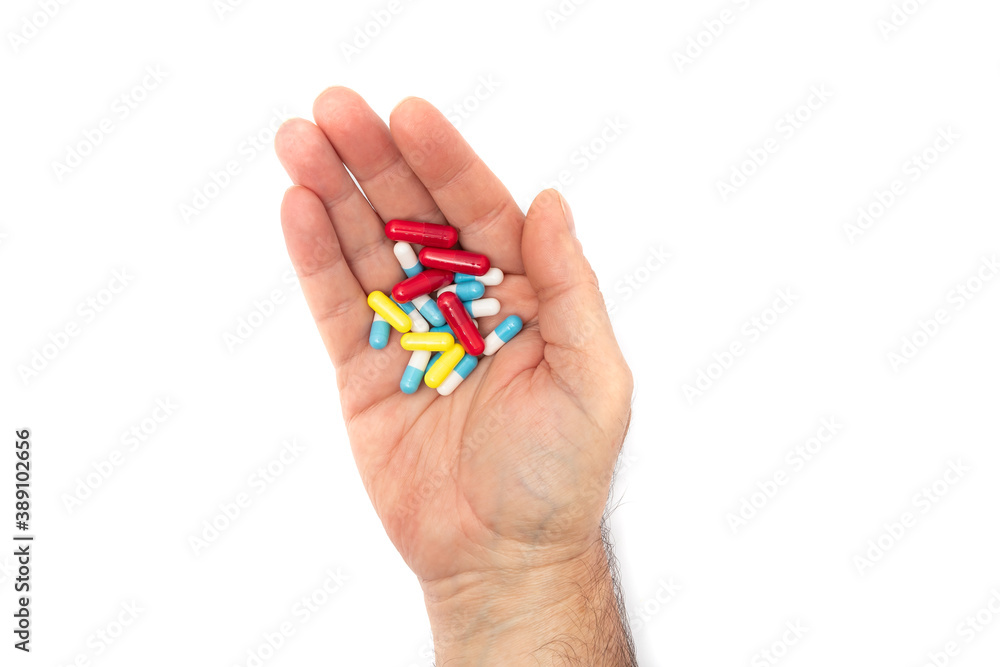 A man hand with multiple colors pills on white background, concept for take your medication