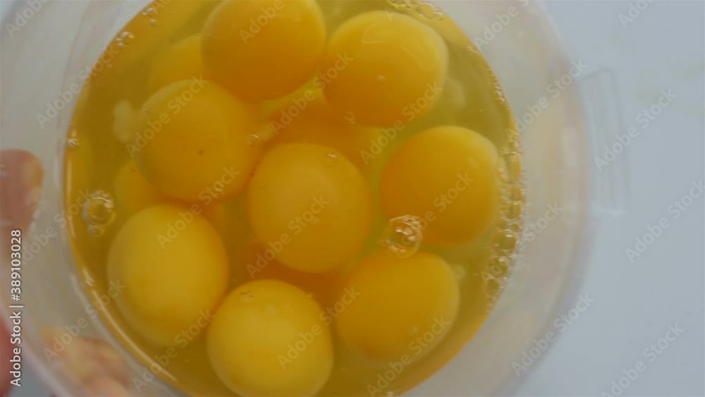 Broken chicken egg. The female hand rotates the container and removes the eggs from the frame. Real time, contains people, close-up Broken chicken egg. The female hand rotates the container and removes the eggs from the frame. Real time, contains people, close-up