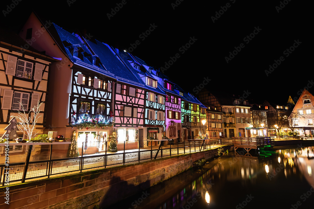 Traditional Alsatian half-timbered houses and river Lauch in Petite Venise or little Venice, old town of Colmar, decorated and illuminated at christmas time, Alsace, France