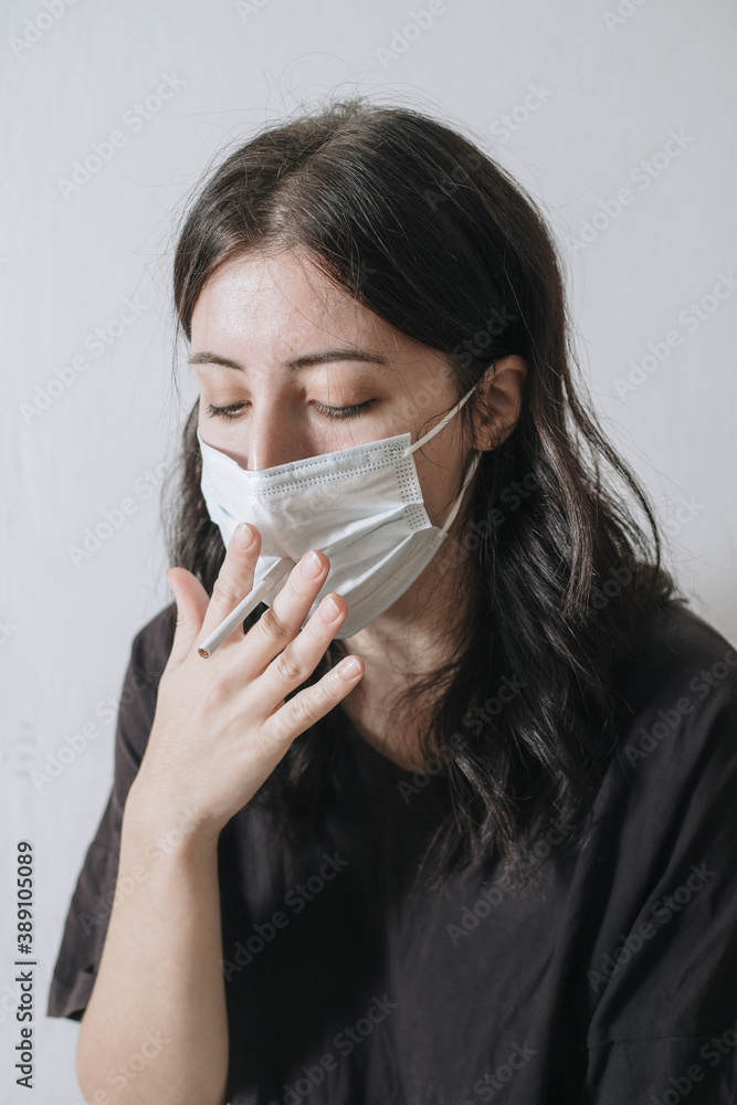 Armenian smoker tries to smoke through a mask from coronavirus, but she does not work out and she is sad Armenian smoker tries to smoke through a mask from coronavirus, but she does not work out and she is sad