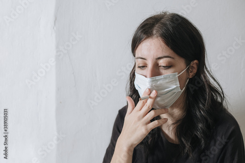 Armenian smoker tries to smoke through a mask from coronavirus, but she does not work out and she is sad
