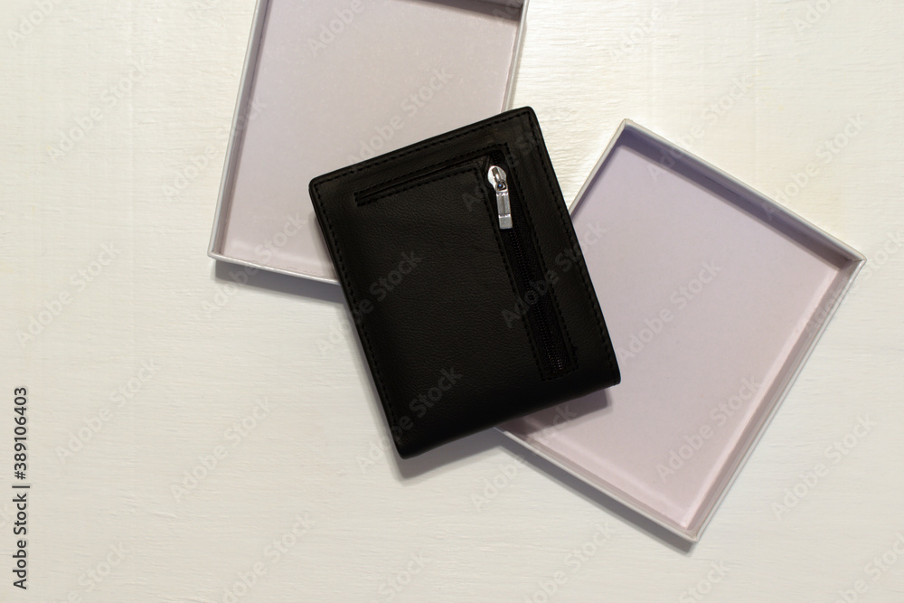 black wallet with packing box on blurred white background with place for text. flat lay black wallet with packing box on blurred white background with place for text. flat lay