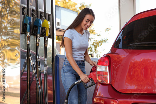Fotografia Young woman refueling car at self service gas station