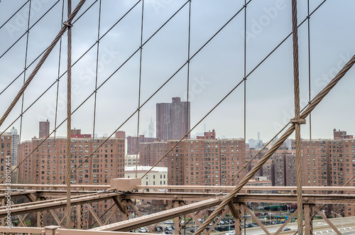 Manhattan New York City Covered in Fog. View Through Brooklyn Bridge Cables
