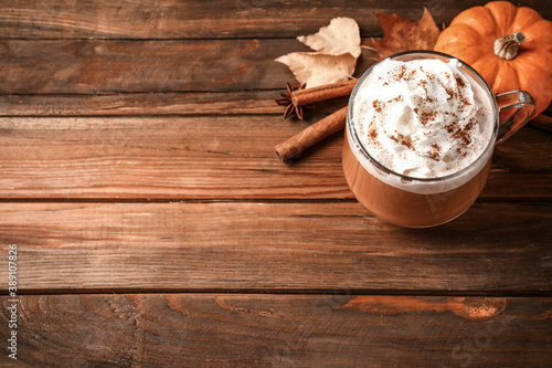 Delicious pumpkin latte on wooden table, above view. Space for text