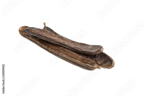 Dried carob tree fruits isolated on white background.