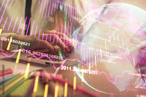 Double exposure of woman hands typing on computer and financial graph hologram drawing. Stock market analysis concept.