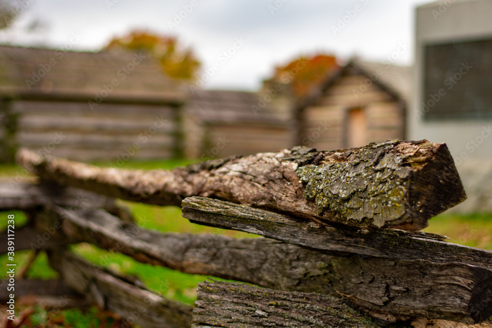 A Wooden Fence With Log Huts Behind It A Wooden Fence With Log Huts Behind It
