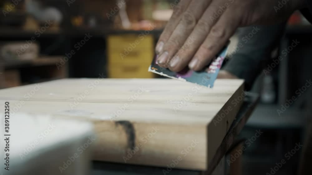 A carpenter applies a putty to a loft-style chair made of wood. A carpenter applies a putty to a loft-style chair made of wood.