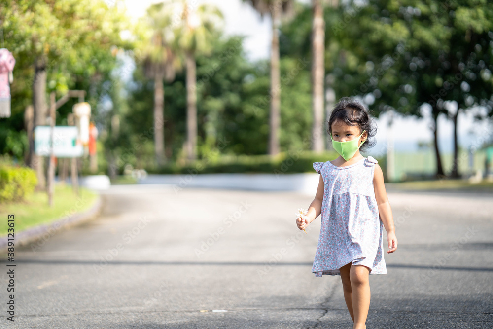 Little girl walking at street with protective face mask to prevent virus and pm2.5 Little girl walking at street with protective face mask to prevent virus and pm2.5