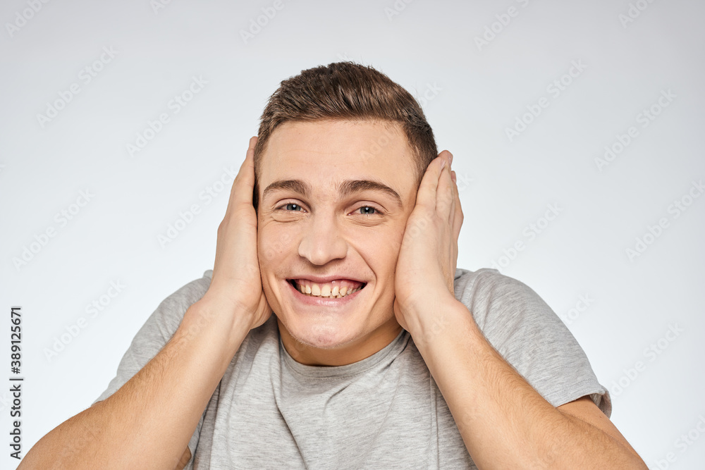 Cheerful emotional man gray t-shirt gesturing with hands studio lifestyle Cheerful emotional man gray t-shirt gesturing with hands studio lifestyle