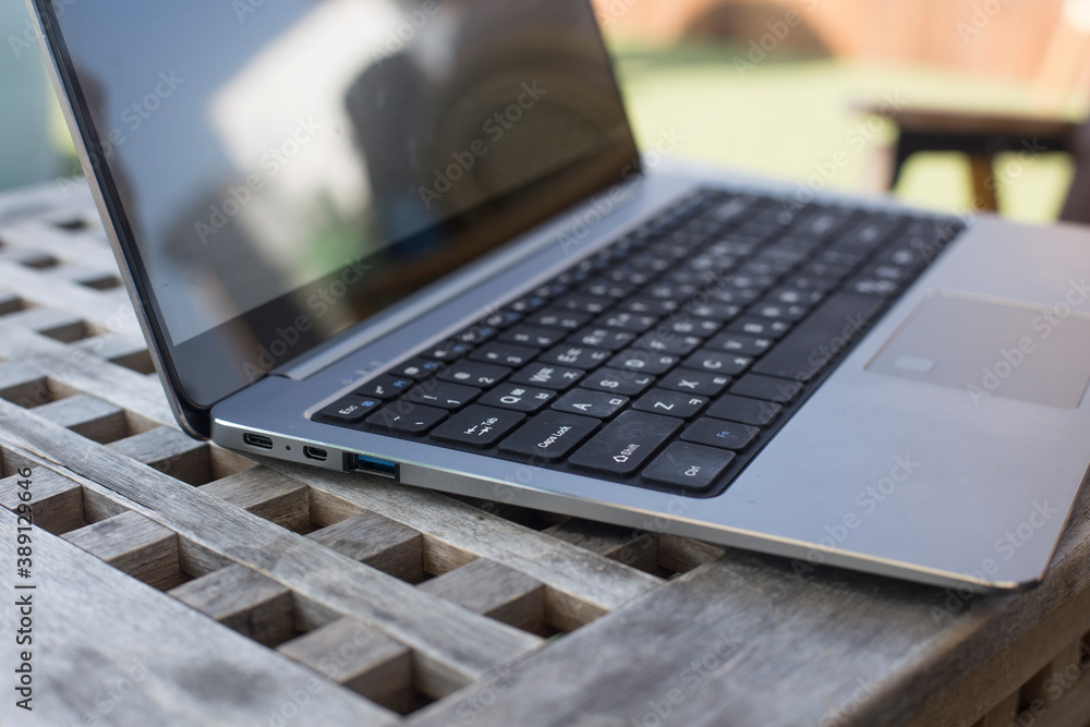 Modern silver opened laptop on the old wooden table.