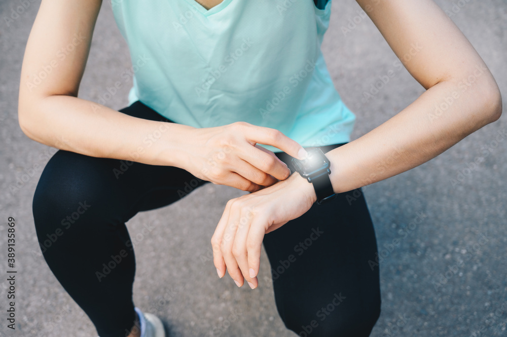 Cropped shot of runner woman checking health status and fitness progress on her smart watch.