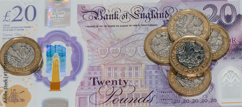 British Curreny. Twenty pound note with pound coins scattered on it - in a web banner format. photo