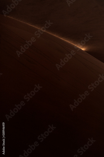 Sand blowing from the top of a Sand dune at first light, Sossusvlei, Namibia.