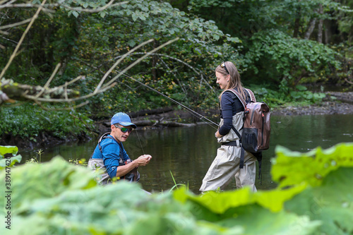 Young woman learning to fly fishing with a profesional guide