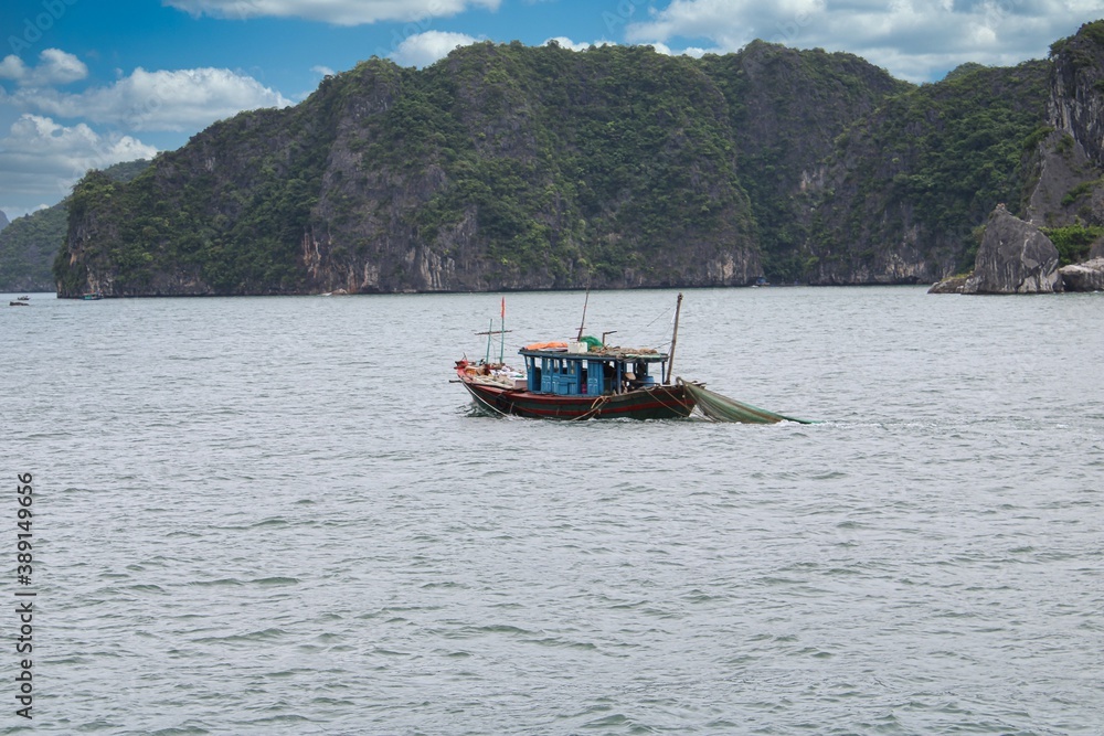 Fishermen at work on their boat in Halong Bay in Vietnam Fishermen at work on their boat in Halong Bay in Vietnam