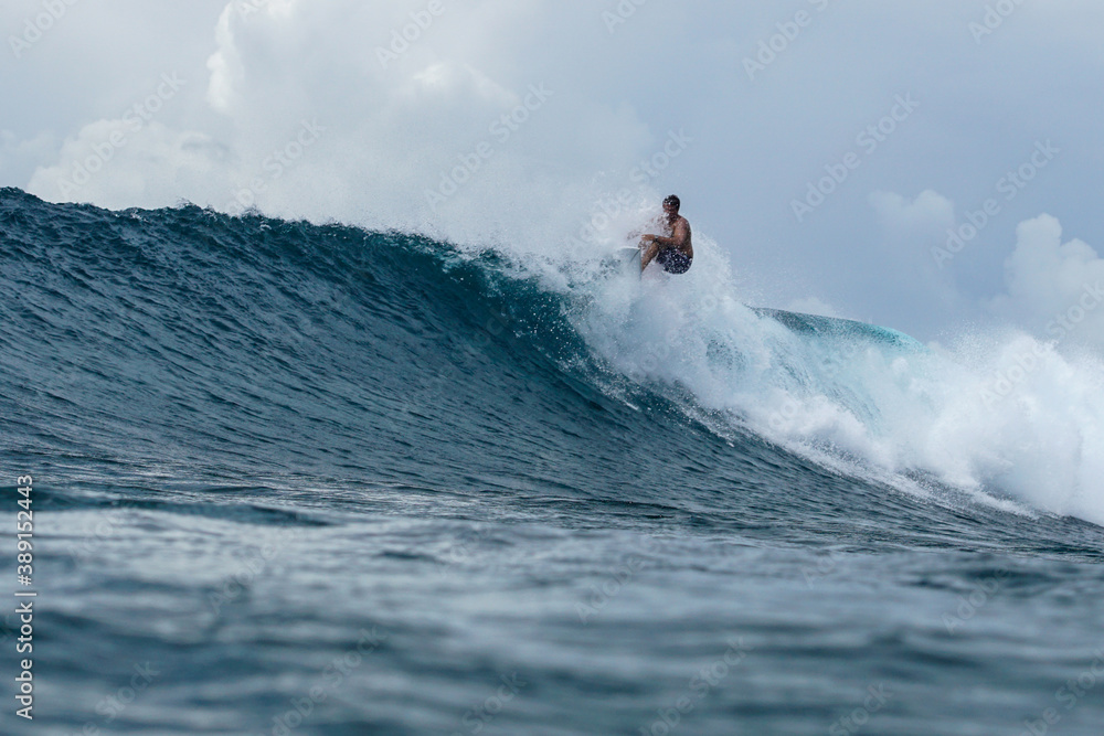 Surfer on perfect blue aquamarine wave, empty line up, perfect for surfing, clean water, Indian Ocean Surfer on perfect blue aquamarine wave, empty line up, perfect for surfing, clean water, Indian Ocean