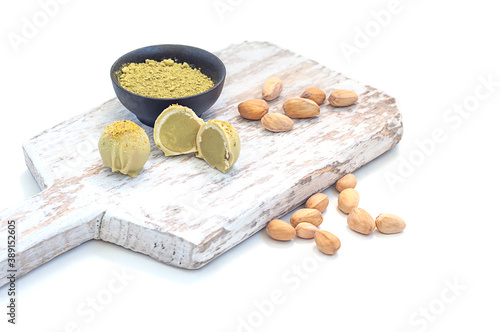Pistachio matcha white chocolate and candy on a wooden board, on a white background.