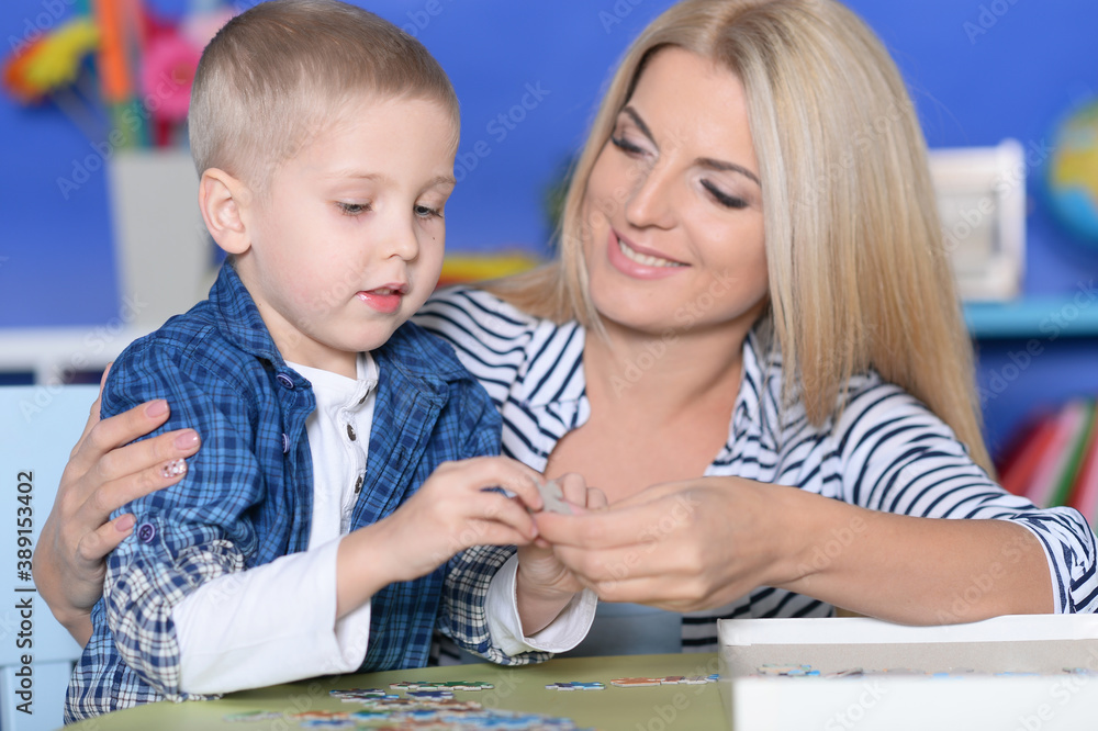 Woman and little boy playing with puzzles Woman and little boy playing with puzzles