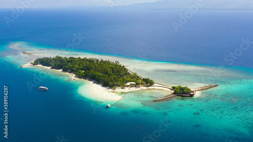 Aerial view of Little Liguid Island with sand beach, palm trees by atoll with coral reef. Little Cruz Island, Philippines, Samal.
