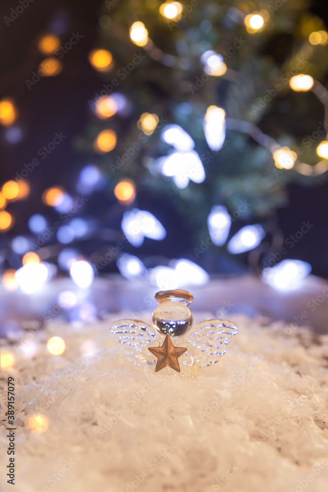 Obraz premium a small glass angel near the Christmas tree. Christmas decoration