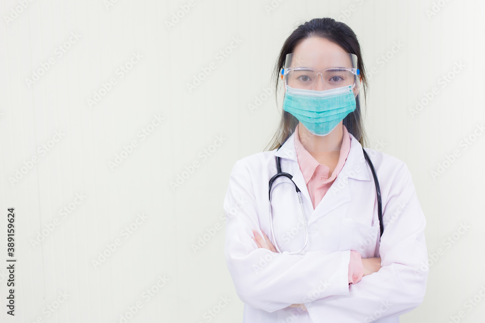 Asian woman doctor in white lab coat wears medical face mask and face shield to protect Coronavirus (Covid). Asian woman doctor in white lab coat wears medical face mask and face shield to protect Coronavirus (Covid).