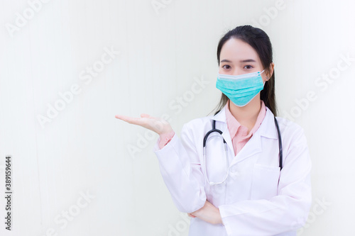 Asian woman doctor wears medical face mask and face shield  to protect Coronavirus (Covid 19) or pathogen in health care concept and shows hand up on white background.