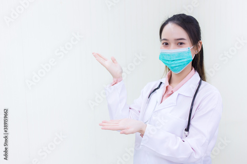 Asian woman doctor wears medical face mask  to protect Coronavirus (Covid 19) or pathogen in health care concept and shows hand up on white background.