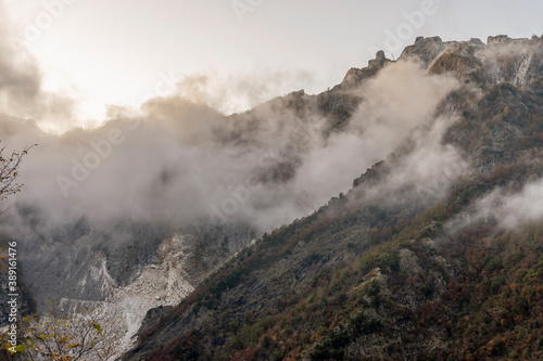View of the Cervaiole marble quarry at sunset, shrouded in fog and low clouds, Seravezza, Apuan Alps, Italy