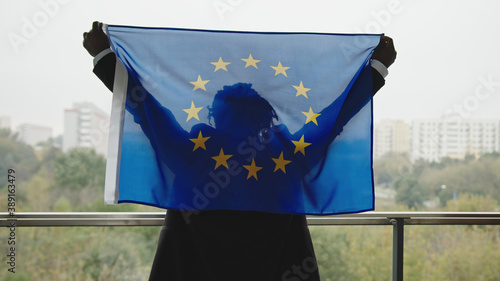 Young african american elegant man holding EU flag on the balcony. High quality photo photo