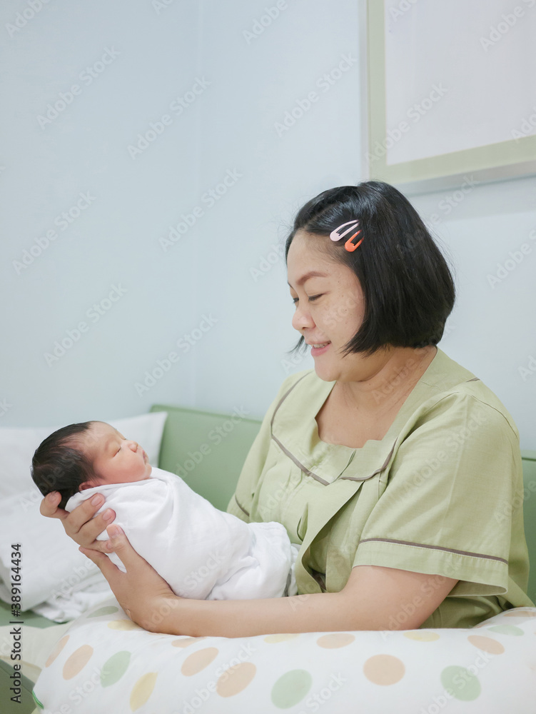 Happy Asian mother holding her little newborn bab Happy Asian mother holding her little newborn bab