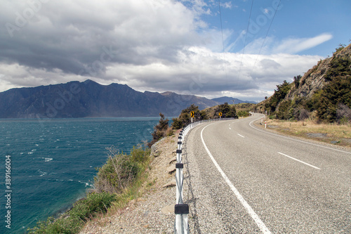 Road trip alongside lake Hawea on the South Island - New Zealand with dramatic cloud formations over the mountains.  photo