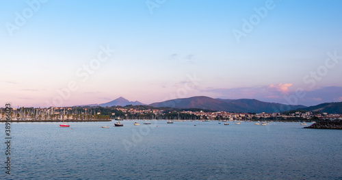 Maritime villages by the sea at sunset time. Leisure boats and fishing boats at the harbor of the Bidasoa estuary. Mount La Rhune behind. Hondarribia   Ir  n   Hendaye  Euskadi  Basque Country  Spain