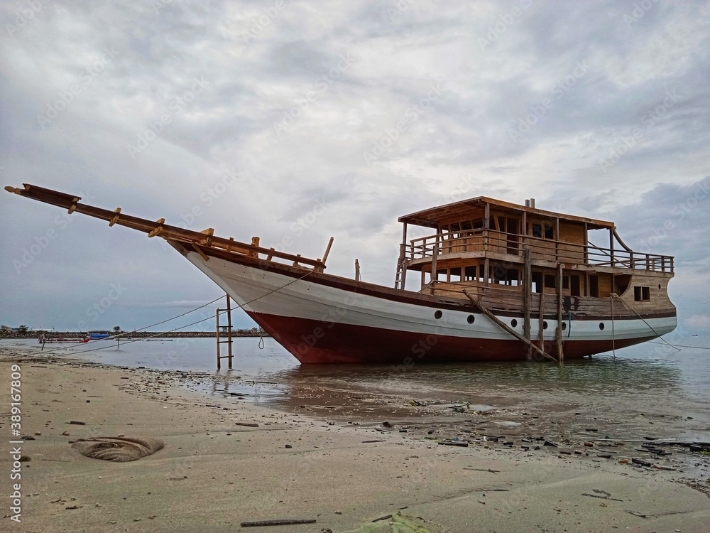 the pinisi ship has finished parking on the edge of the sea ready for trials