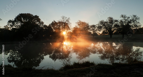 Sunbeams and reflections on a foggy dawn in golden light