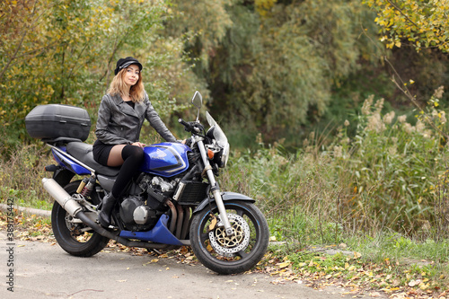 Beautiful slim woman sitting on the motorcycle