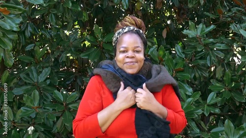 Happy and smiling Black woman looking directly at camera with scarf on Winter photo