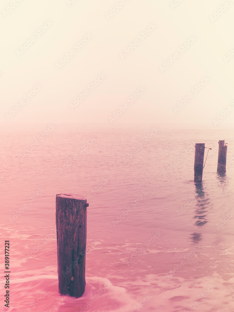 Retro style seascape photo with three pilings of ruined piers Retro style seascape photo with three pilings of ruined piers