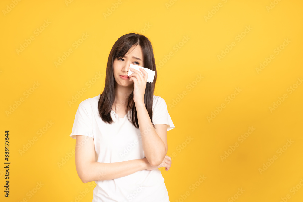 Asian young woman wearing white t-shirt standing and crying Asian young woman wearing white t-shirt standing and crying