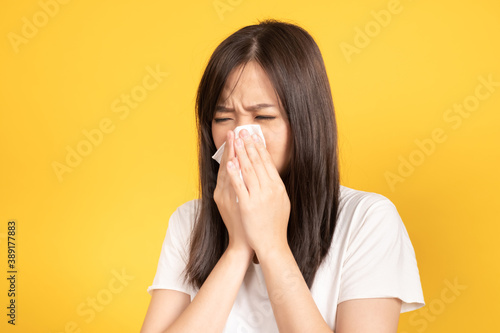 Young asian woman wearing face mask under the outbreak sneezing