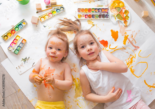 Children learn to paint. Portraits of children in watercolor paint. View from above