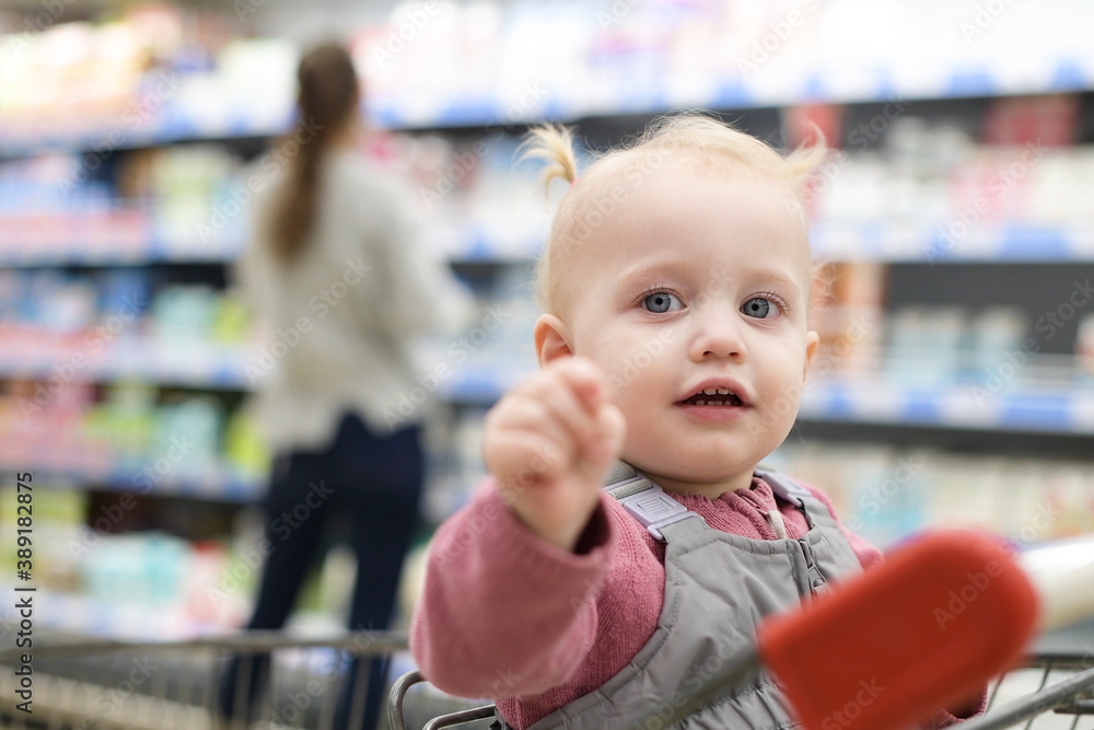 little girl sitting in a grocery cart and waiting for mom little girl sitting in a grocery cart and waiting for mom